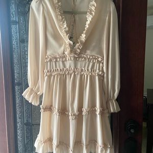 Ruffled long sleeve dress. Fits above the knee. Opened back with buttons.